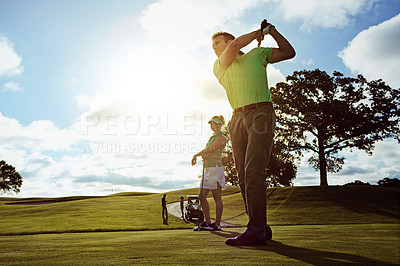 Buy stock photo Shot of a couple playing golf together on a fairway