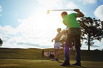 Buy stock photo Shot of a couple playing golf together on a fairway