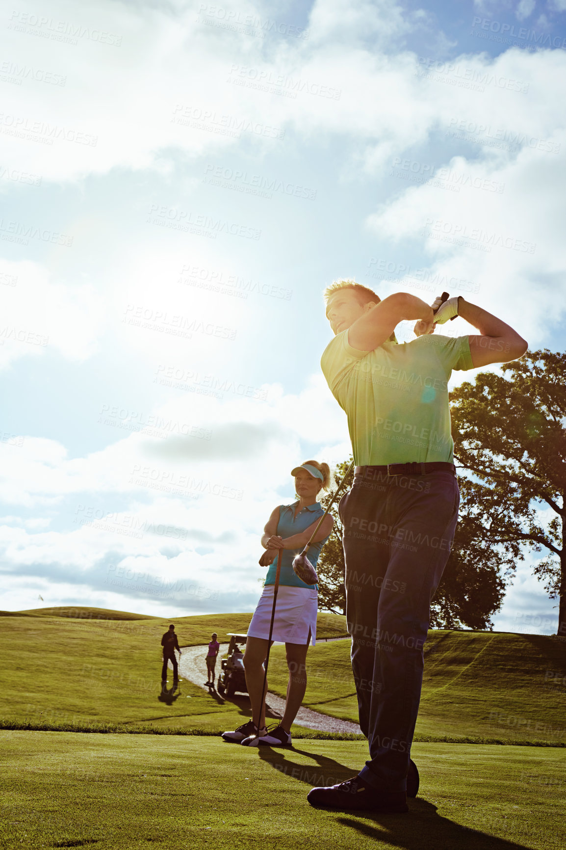 Buy stock photo Shot of a couple playing golf together on a fairway