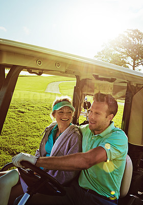 Buy stock photo Shot of a couple riding in a golf cart on a golf course