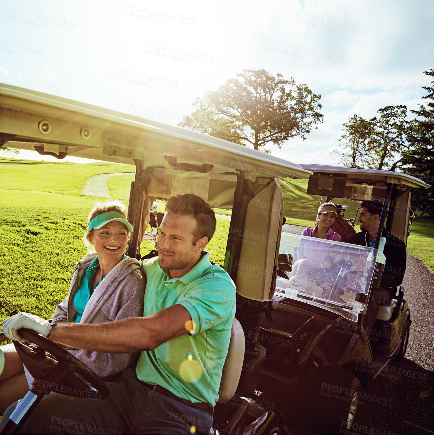 Buy stock photo Shot of a group of friends riding in a golf cart on a golf course