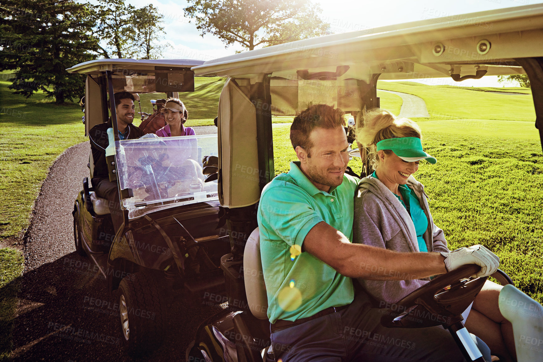 Buy stock photo Shot of a group of friends riding in a golf cart on a golf course