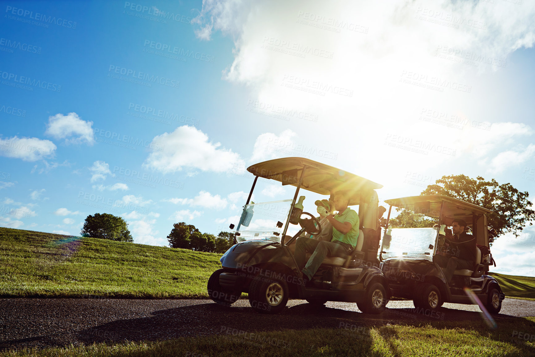 Buy stock photo Shot of a group of friends riding in a golf cart on a golf course