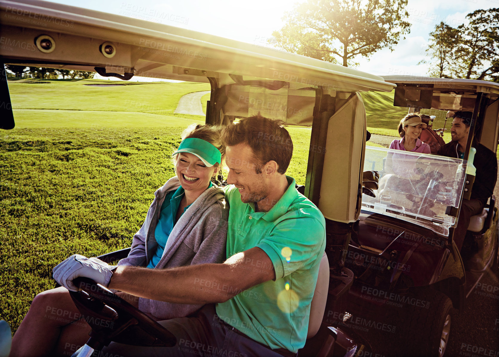 Buy stock photo Shot of a group of friends riding in a golf cart on a golf course