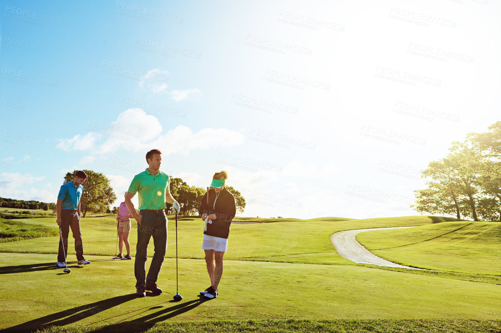 Buy stock photo Shot of two couples playing a round of golf together on a sunny day