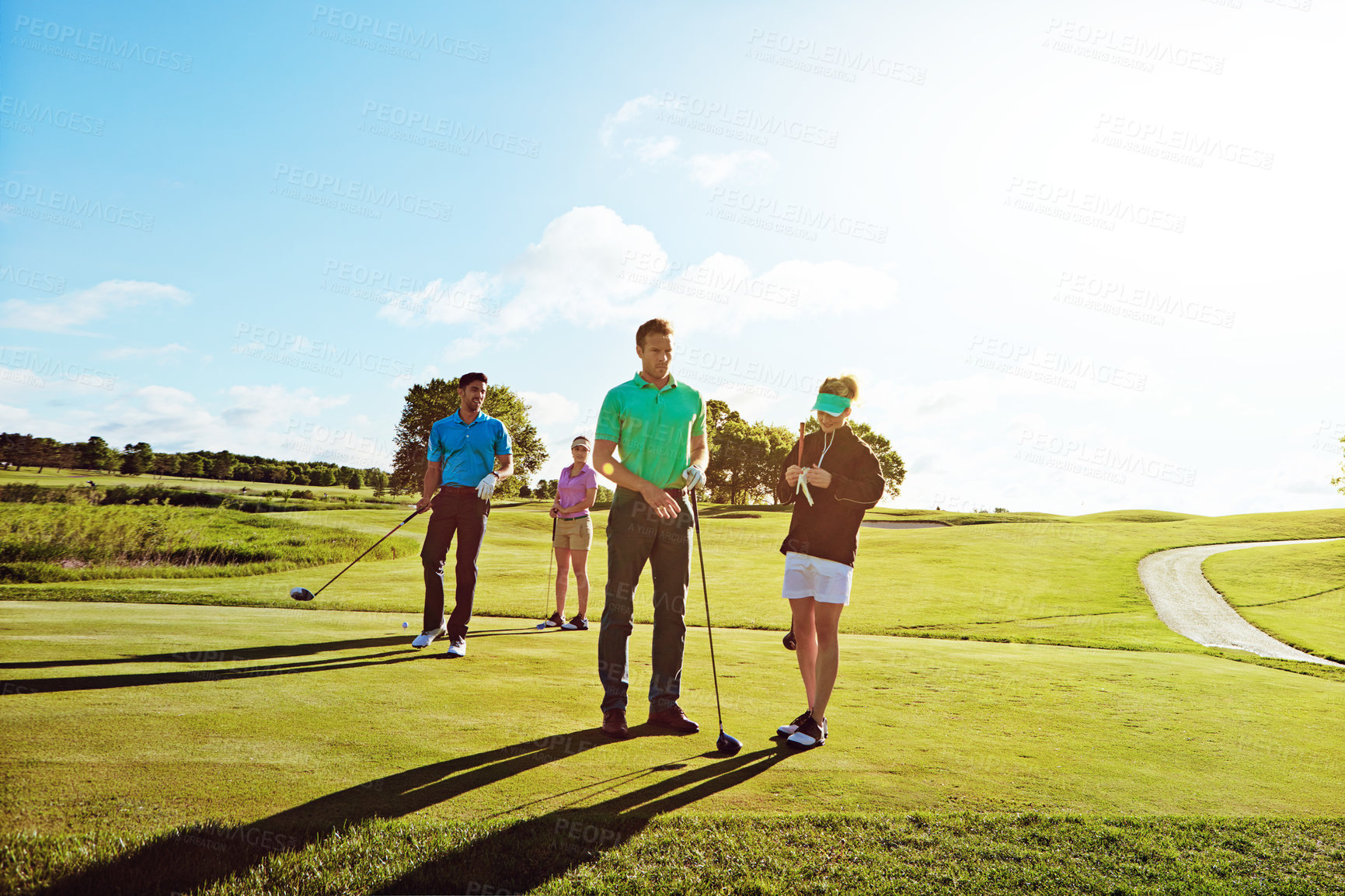 Buy stock photo Shot of two couples playing a round of golf together on a sunny day