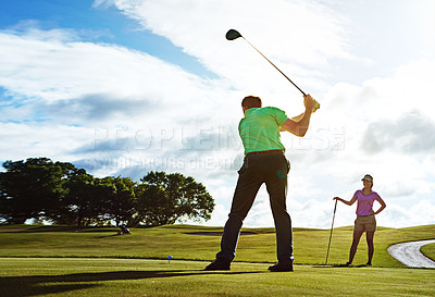 Buy stock photo Shot of a couple playing golf together on a fairway