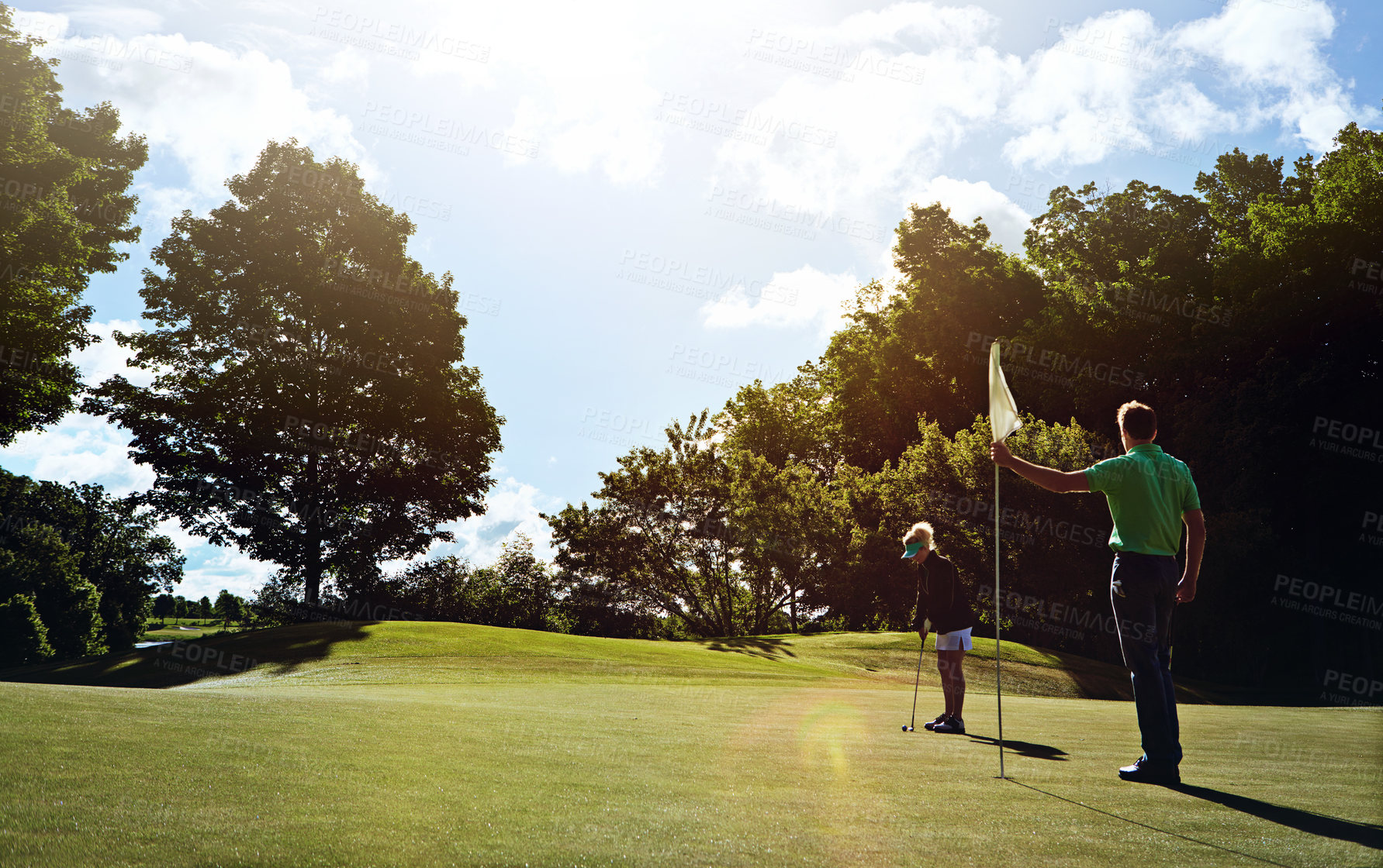 Buy stock photo Shot of a couple playing golf together on a fairway