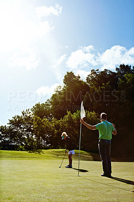 Buy stock photo Shot of a couple playing golf together on a fairway