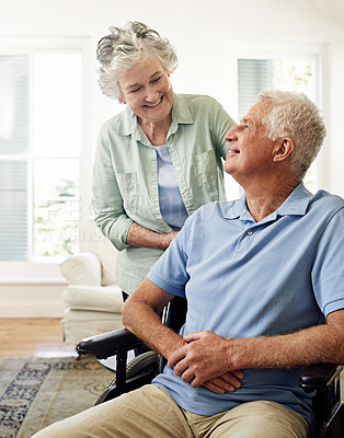 Buy stock photo Shot of a smiling senior man in a wheelchair and his wife at home