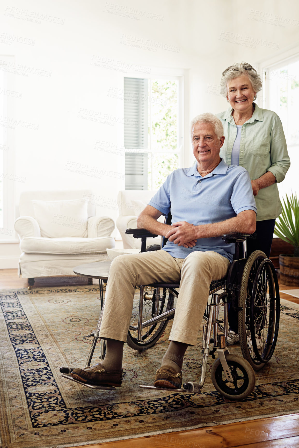 Buy stock photo Disability, smile and portrait of senior couple at home for marriage, quality time and bond together. Retirement, wheelchair and happy elderly woman and man in living room to relax, support and love