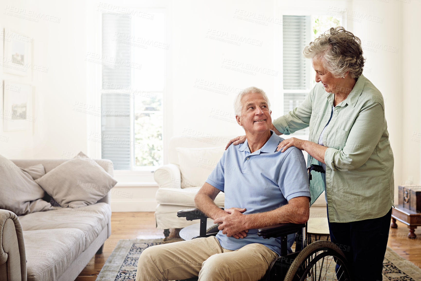 Buy stock photo Shot of a smiling senior man in a wheelchair and his wife at home