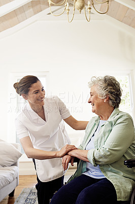 Buy stock photo Shot of a smiling caregiver helping a senior woman in a wheelchair at home