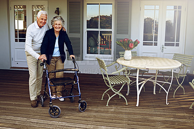 Buy stock photo Portrait of a smiling senior woman using a walker with her husband beside her outside their home