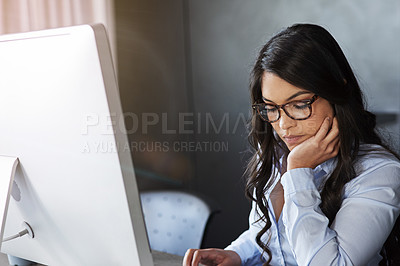 Buy stock photo Shot of a young businesswoman sitting at her desk in the office