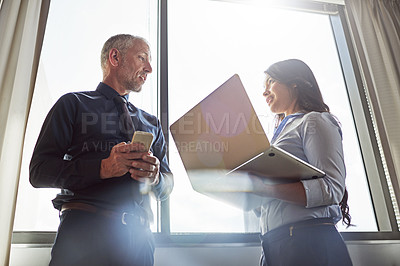 Buy stock photo Shot of a young businesswoman addressing a male colleague