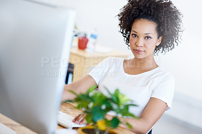 Buy stock photo Portrait of a focused young designer working on a computer at a desk in an office