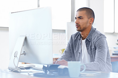 Buy stock photo Shot of a young designer working on a computer at a desk in an office