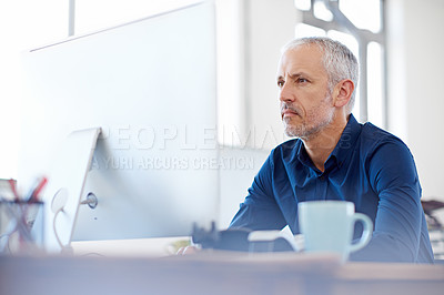 Buy stock photo Shot of a mature designer working on a computer at a desk in an office