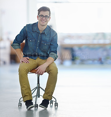 Buy stock photo Portrait of a smiling young designer sitting on a chair in a large office