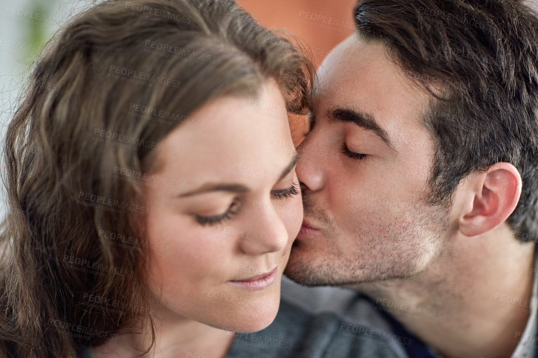 Buy stock photo Kiss, love and face of couple in home for care, support and bonding together in apartment. Romance, man and woman with connection for healthy relationship, marriage or commitment for partnership