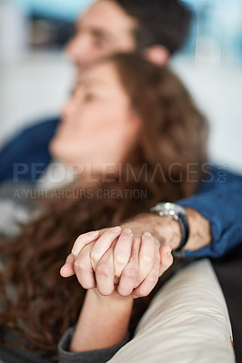 Buy stock photo Love, holding hands and couple on a sofa with care, trust and support while bonding at home together. Fingers, marriage and people in a living room with security, safety and calm weekend in a house