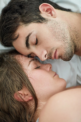 Buy stock photo Shot of a relaxed young couple sleeping in bed together at home