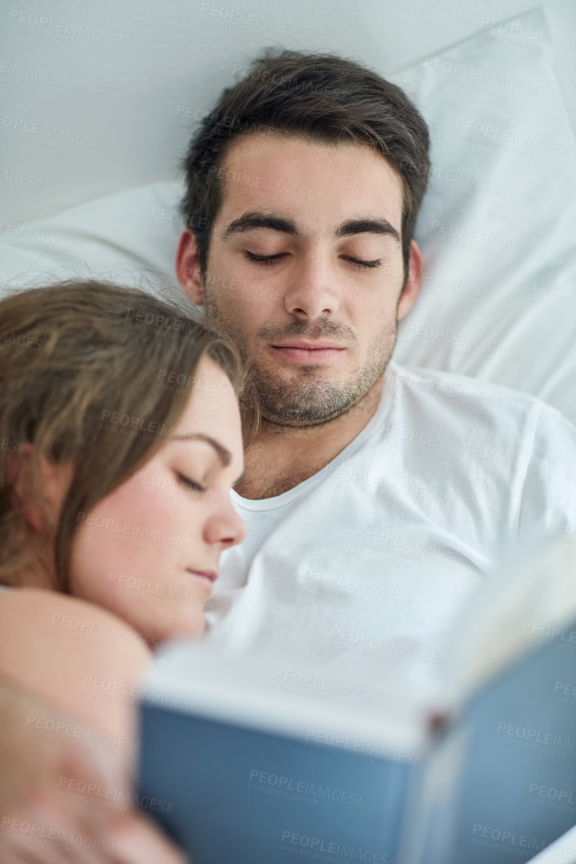 Buy stock photo Love, relax and couple in bed with book, comfort and peace, care and bonding in their home from above. Calm, reading and male person with novel in bedroom with sleeping wife on weekend in a house