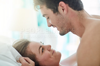 Buy stock photo Happy, love and couple in bed with romance, intimacy and desire, connection and bonding in their home together. Foreplay, eye contact and people in a bedroom with passion for honeymoon or anniversary