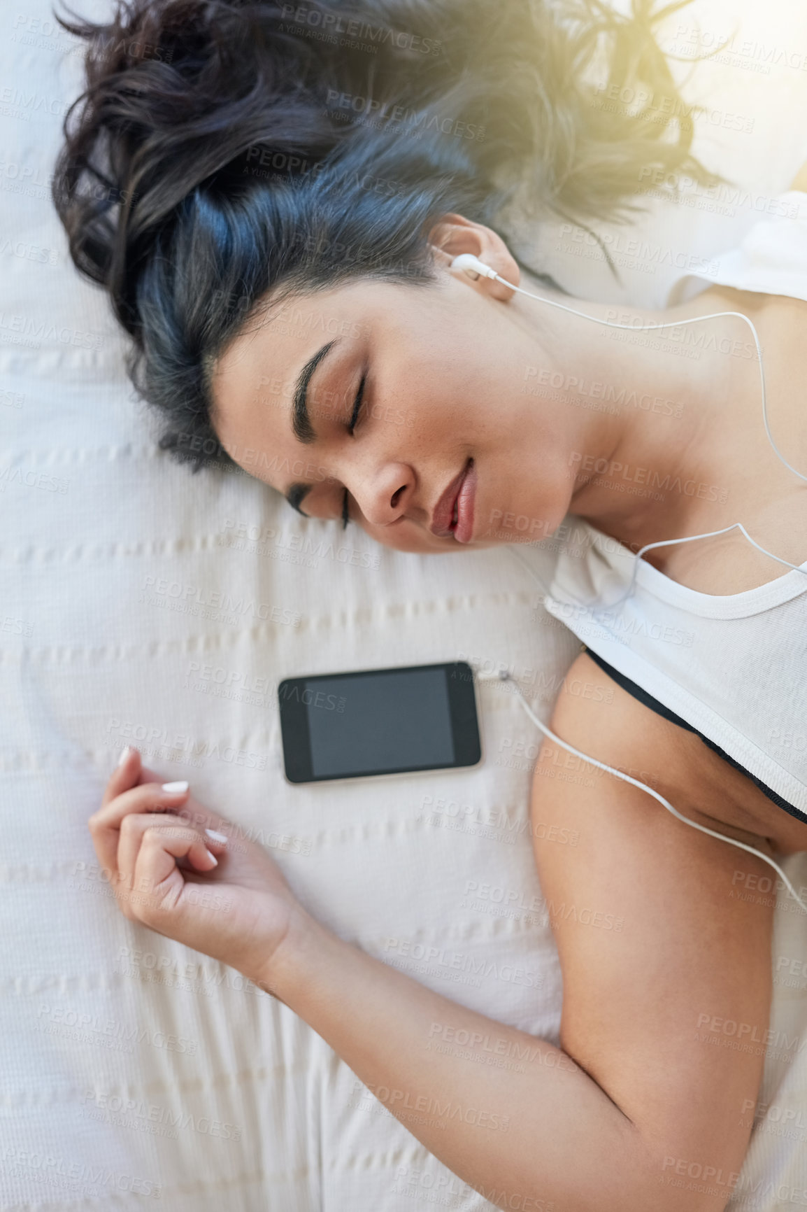 Buy stock photo Woman, earphone and music in bed with cellphone, audio and rest in home. Calm, listen and peace in bedroom for lazy day on weekend with podcast, comfortable and sleep or self care for female person 