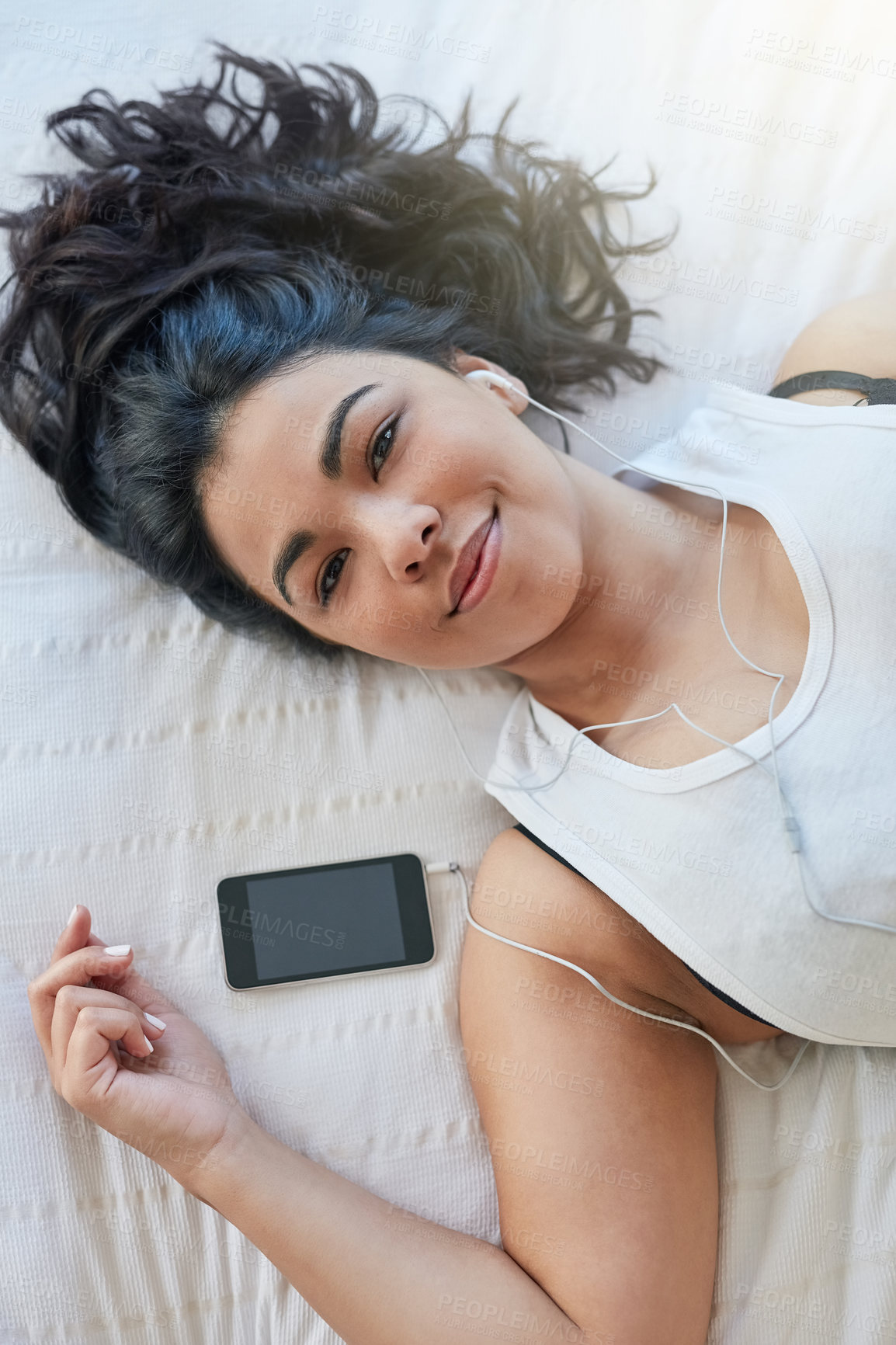 Buy stock photo Woman, earphone and music in bed with cellphone, audio or rest in home. Calm, portrait and peace in bedroom for lazy day on weekend with podcast, comfortable and sleep or self care for female person 