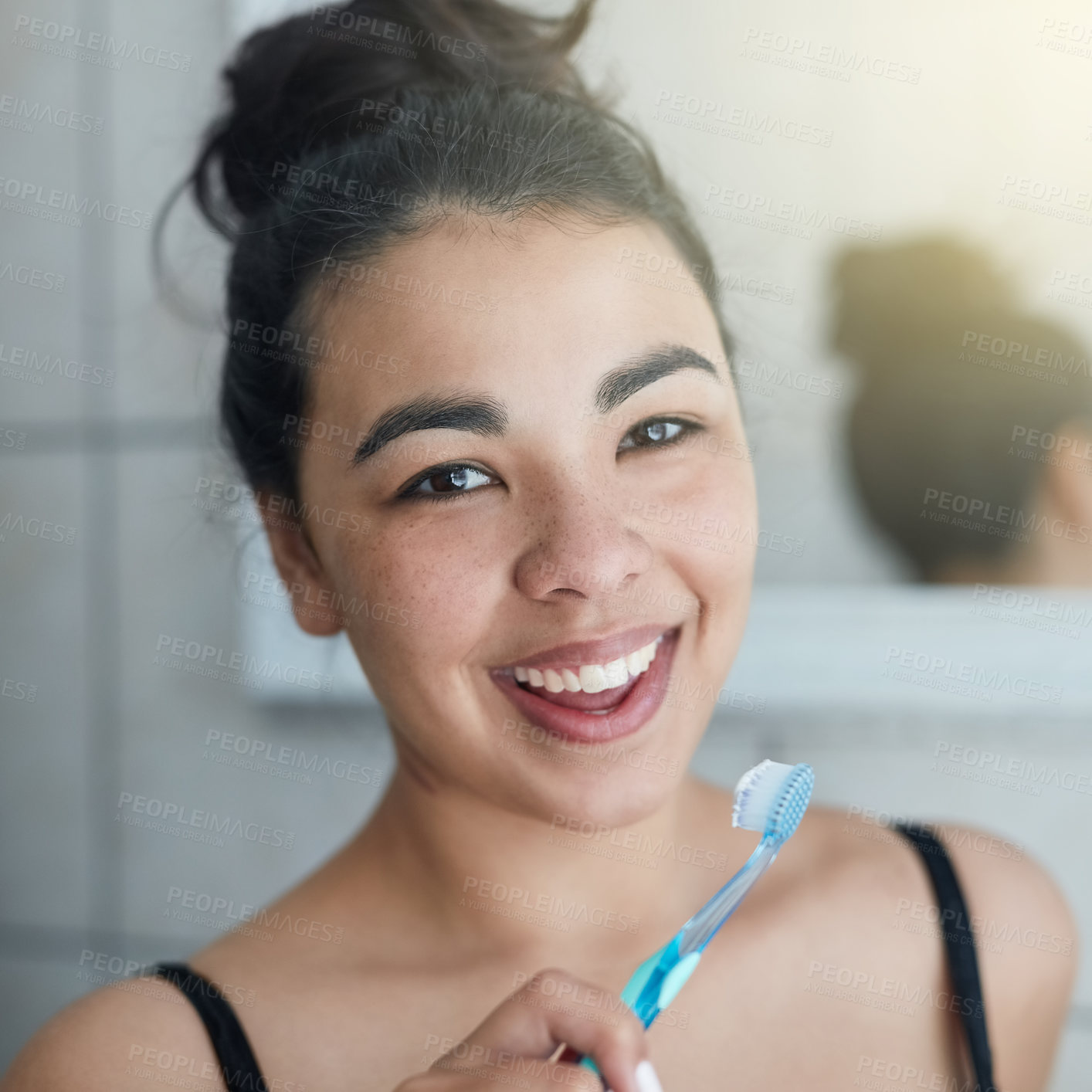 Buy stock photo Portrait of an attractive young woman brushing her teeth in the bathroom