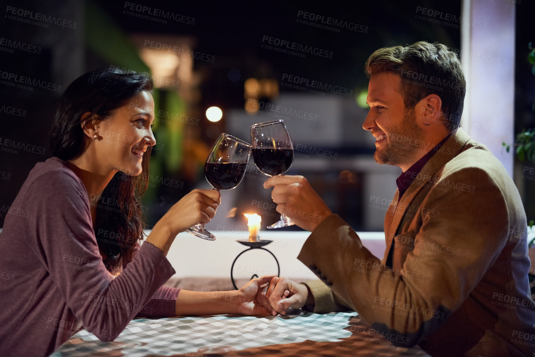 Buy stock photo Cropped shot of an affectionate young couple having a romantic dinner in a restaurant