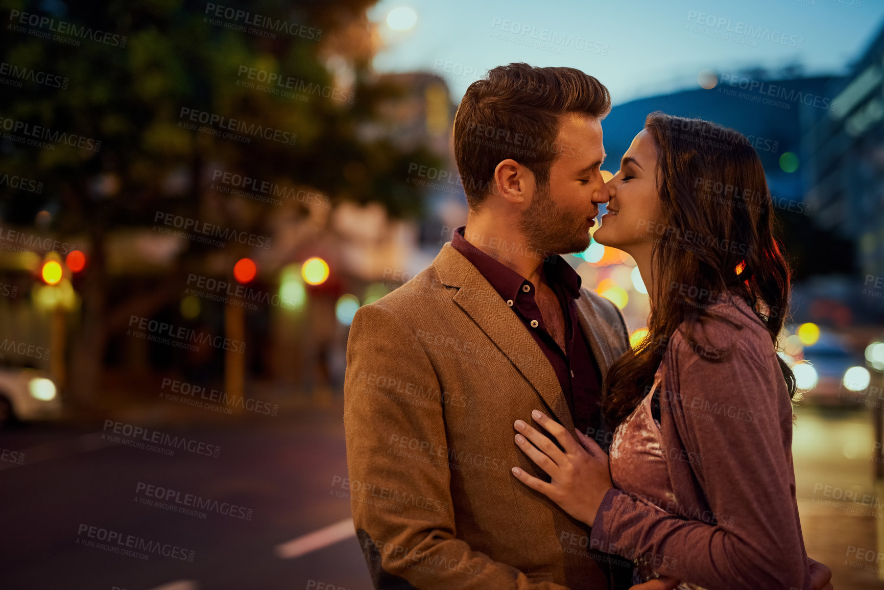 Buy stock photo Couple, night and city street with hug and kiss on date, romance and bonding with love in relationship. Affection, people with commitment and trust, sweet moment and romantic together outdoor