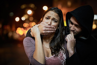Buy stock photo Woman, criminal and hand on mouth with fear for violence, danger and robbery in city at night with bokeh. People, portrait and silence emoji with terror, crime and stalker for kidnapping and hostage