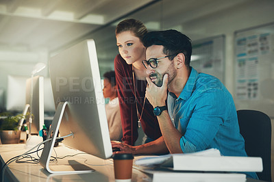 Buy stock photo Cropped shot of two young businesspeople looking at a computer screen