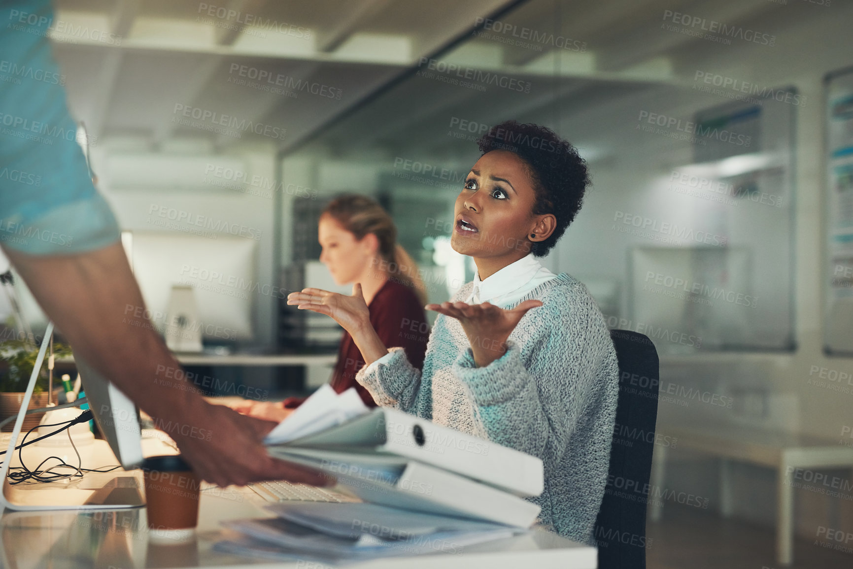 Buy stock photo Shot of a young businesswoman looking overwhelmed while receiving even more work from a colleague