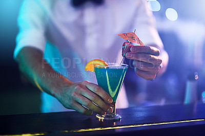 Buy stock photo Cropped shot of a bartender serving a freshly made cocktail at a bar