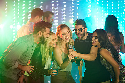 Buy stock photo Shot of a group of friends singing karaoke at a party