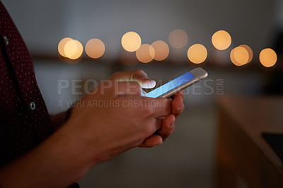 Buy stock photo Closeup shot of an unidentifiable person texting on a cellphone outside at night