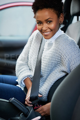 Buy stock photo Portrait of a young woman fastening her seatbelt in a car