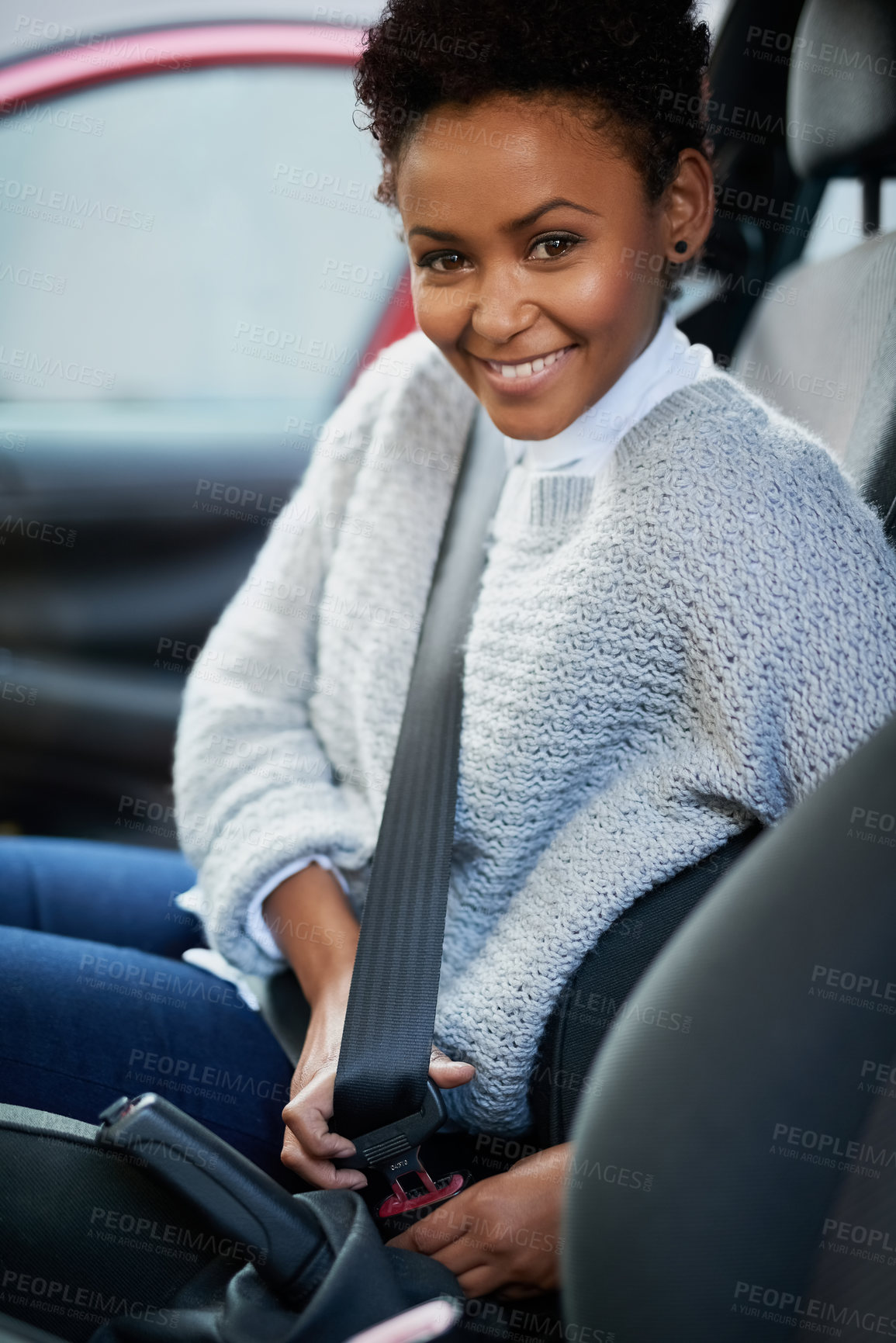 Buy stock photo Portrait of a young woman fastening her seatbelt in a car