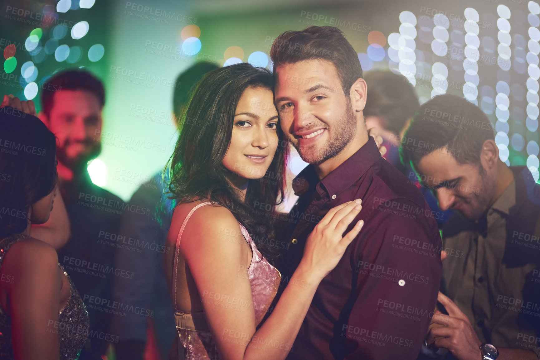Buy stock photo Shot of an affectionate young couple dancing on a crowded dance floor in a nightclub
