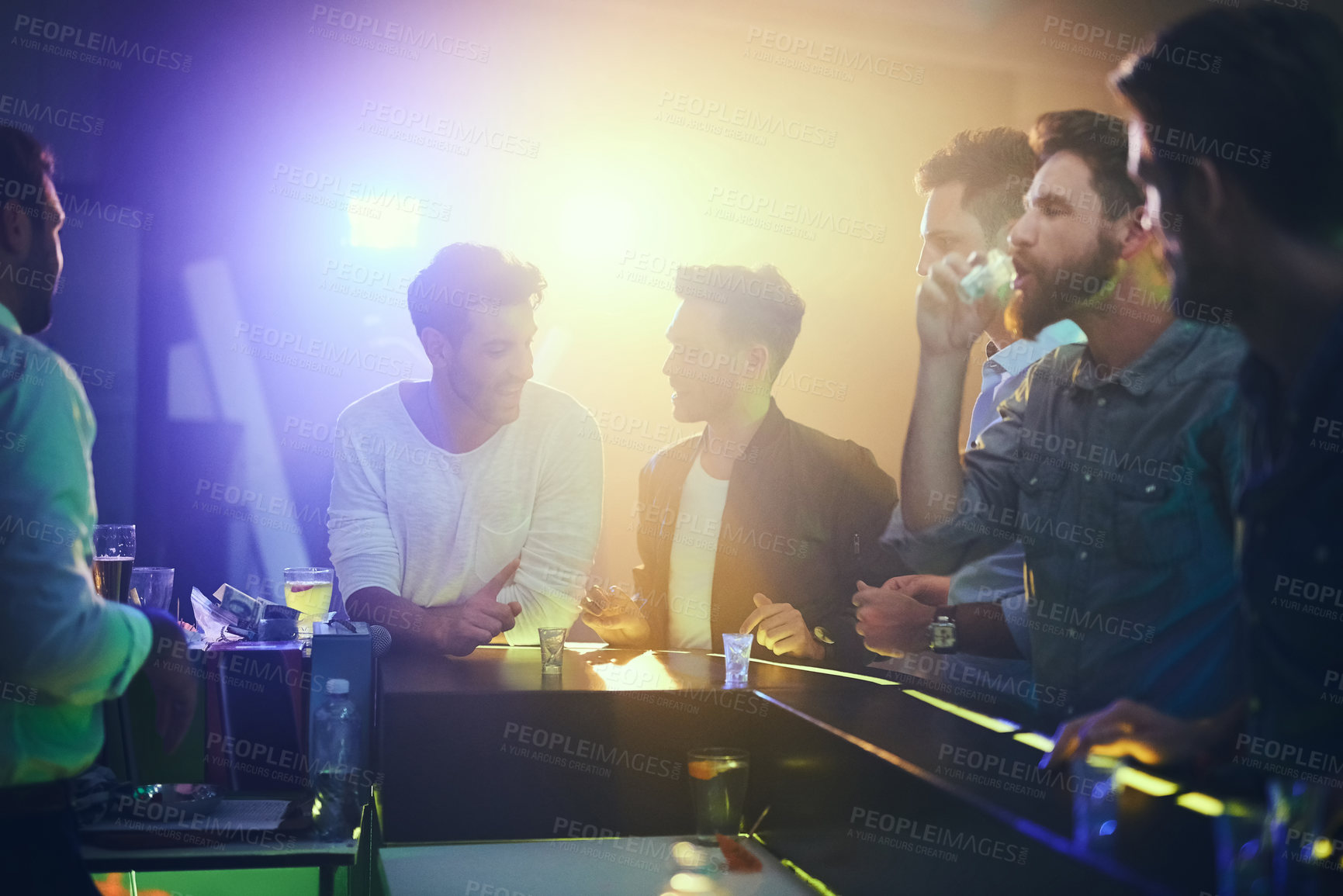 Buy stock photo Shot of a group of friends enjoying shots at the bar in a nightclub