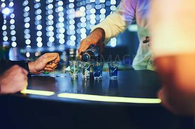 Buy stock photo Shot of an unidentifiable barman pouring shots in a nightclub