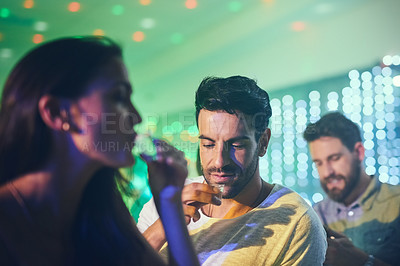 Buy stock photo Shot of a group of friends enjoying shots at the bar in a nightclub