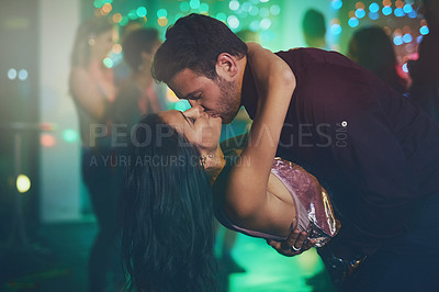 Buy stock photo Shot of an affectionate young couple dancing on a crowded dance floor in a nightclub