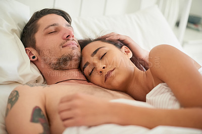 Buy stock photo Shot of an affectionate young couple cuddling in their bed at home
