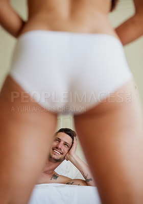 Buy stock photo Man smiling, couple and sexy legs in bedroom for striptease, seduction and kinky at home. Male person, excited and butt in panties for intimacy, playful or affection in motel or hotel for making love