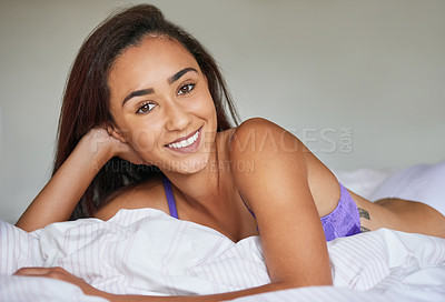 Buy stock photo Portrait of a beautiful young woman in lingerie lying on her bed